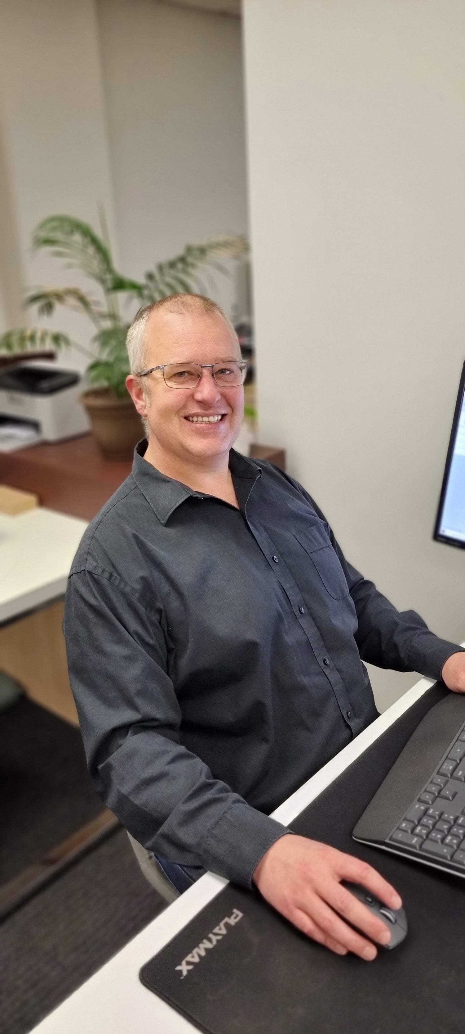 Smiling man wearing a black shirt and glasses