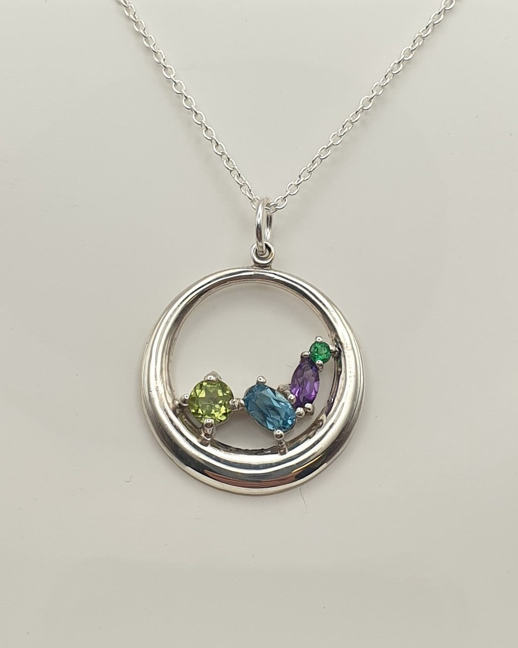 Green blue and purple coloured stones on silver necklace